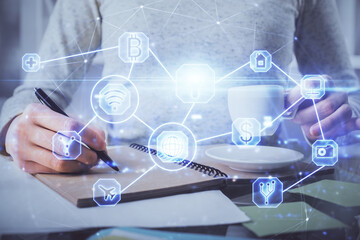 Social network theme hologram over hands taking notes background. Concept of global international people connect. Double exposure