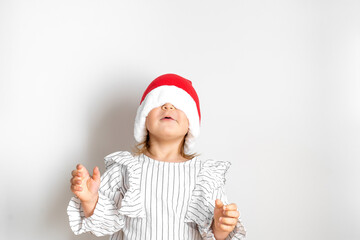 Portrait of toddler girl in red hat on Christmas. Surprise concept