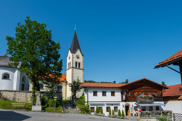 Fototapeta na wymiar Pfarrkirche und Kirchplatz im Ortskern von Sankt Englmar im Bayerischen Wald in der Oberpfalz in Bayern im Sommer bei blauem Himmel