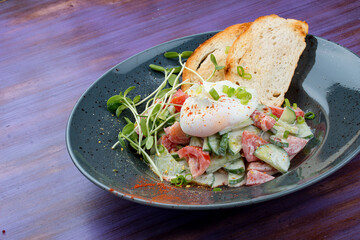 Homemade salad with vegetables and poached egg. Breakfast.