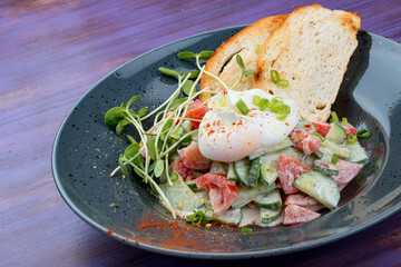 Homemade salad with vegetables and poached egg. Breakfast.