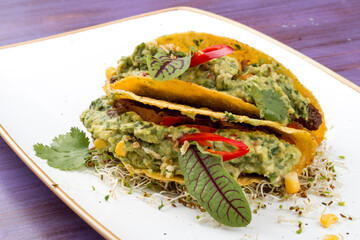 Taco. Corn tortilla with beef and guacamole with spices.