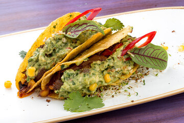 Taco. Corn tortilla with beef and guacamole with spices.