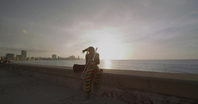 Colorfully Dressed Trombone Performer on Boardwalk in Havana Cuba at Sunset