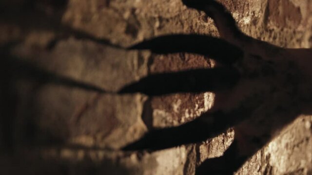 Black scary sharp claws of the devil scrape on a stone wall. Monster hand