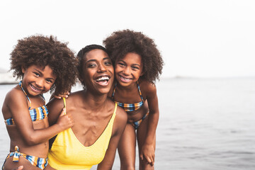Happy African family on the beach during summer holidays - Afro American people having fun on...