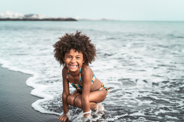Afro American child having fun on the beach - Little kid playing during summer time outdoor - Black...