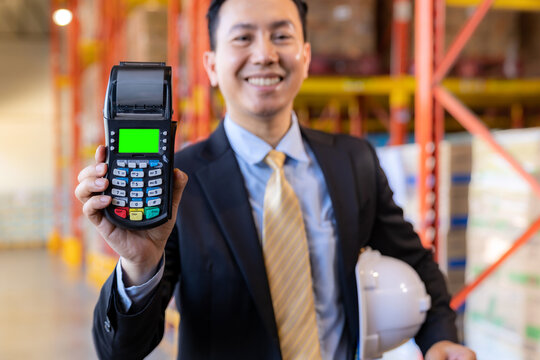 Businessman hold credit card reader in warehouse