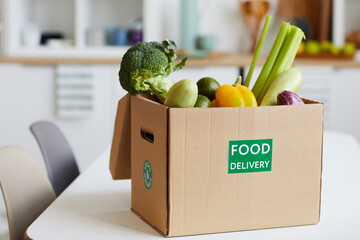 Close-up of fresh vegetables in cardboard box on the table delivered to home