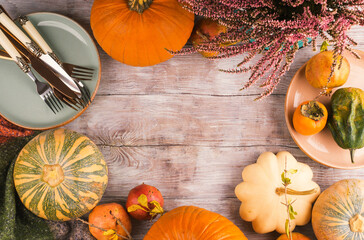 Autumn thanksgiving dinner concept frame background with pumpkins, fall fruit and tableware.