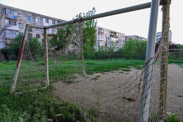 abandoned football field, goal with a torn net in a vacant lot