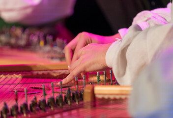 Hand playing on kokle a Latvian plucked string instrument belonging to the Baltic box zither family.