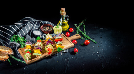 Vegetarian skewers with mixed vegetables (peppers, mushrooms, and onions) on a dark background