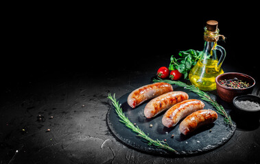 Grilled sausage with the addition of herbs and vegetables on a dark background