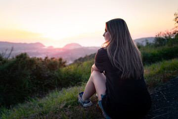 Young girl looking at the sunset from a hill in Donostia-San Sebastian, Basque Country.