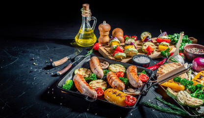 Grilled sausage and mixed vegetables with basil and dry herbs on a dark background