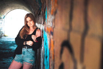 Obraz premium Beautiful young girl posing inside a tunnel in an old fortificacion actually in ruins.