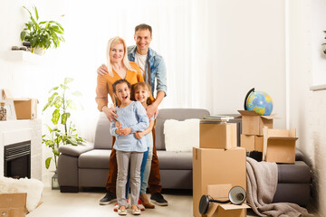 Fototapeta na wymiar Happy family moving home with boxes around