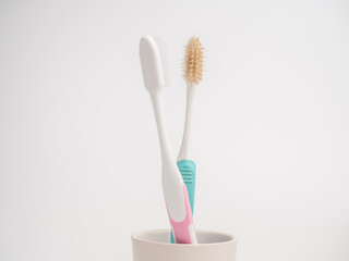 Bad breath concept. New toothbrush woman avoiding bad smell from the old dirty toothbrush man. Pastel toothbrushes on white background.  