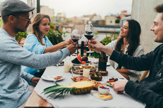 Long Awaited Meeting With Friends, Multicultural Group Of People Having Fun Together Drinking Wine Laughing And Enjoying The Holidays, Family Dinner Outdoors, Friends Celebrating Little Rooftop Party