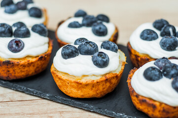 cupcakes with cream, blueberries and mint on a grey background