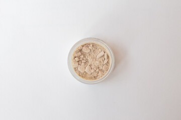 Blusher, eyeshadow and transparent face powder on white background with copy space, close-up.