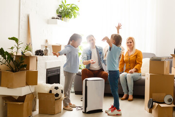 air purifier in living room with happy family moving to new apartment