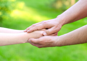 Father male hands holding child hands