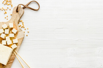 tofu vegan food on cutting board on white table top view copy space