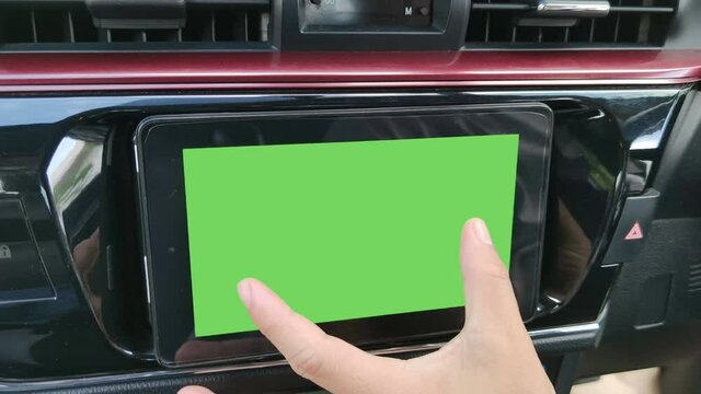 4K footage real time close-up hand of asian man with zoom out gesture on monitor in car used for navigation maps and GPS rear view camera isolated on chroma key green screen background.