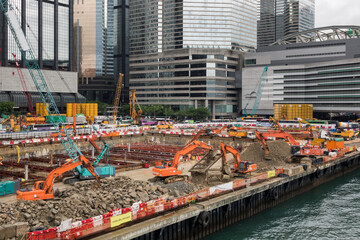 Construction site surrounded by skyscrapers in a big city. Excavators work