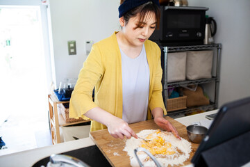 小麦粉と卵を混ぜる、料理中の女性