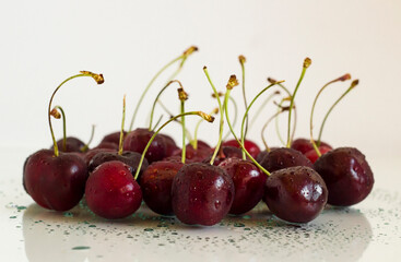 Ripe,fresh cherries on glass table with drops,reflection and copy space,horizontal view