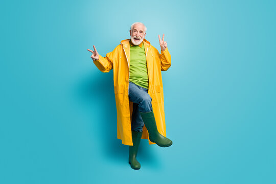 Full length body size view of his he nice cheerful cheery grey-haired man wearing topcoat dancing showing double v-sign good mood isolated over bright vivid shine vibrant blue color background