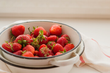 Fresh ripe delicious strawberries in a light plate on a white background. Healthy eating concept.