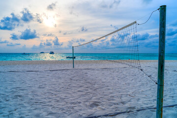Volleyball net on a deserted sandy beach on the tropical sea.