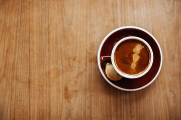 Photo of brown porcelain cup with coffee with milk on wooden table. Snapshot of glass with hot chocolate and cookie