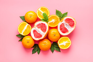 Citrus fruits on pink background top view