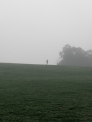 Silhouette of a man running in the fog.