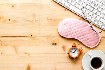 Sleeping on office desk. Concept with sleep mask and laptop top-down copy space