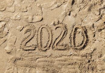 Summer vacation 2020. The inscription, the words written, drawn on the sea sand, top view. Photograph, copy space.