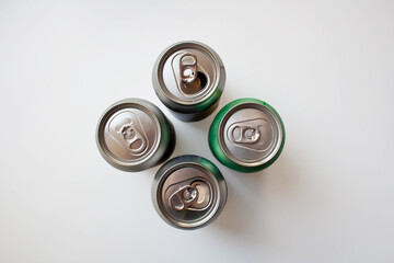 Four metal drink cans isolated on white background from a high angle view