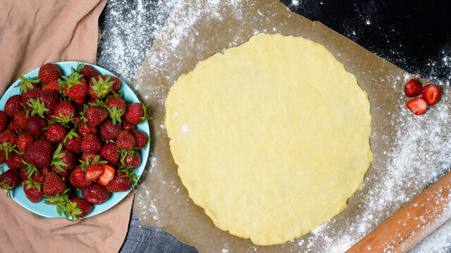 step by step recipe the process of making galetta with strawberries at home, top view on a dark background, ingredients for strawberry pie