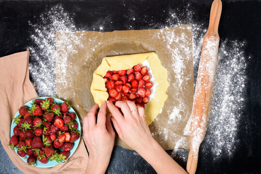 step by step recipe the process of making galetta with strawberries at home, top view on a dark background, ingredients for strawberry pie