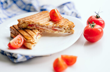 summer breakfast. toast  ham cheese on a white plate in the kitchen, a beautiful serving of food, fresh  cherry tomatoes. delicious recipes. still life