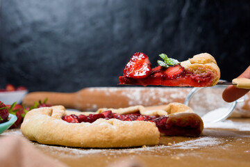 homemade strawberry Galette with fresh ripe strawberries on a dark background