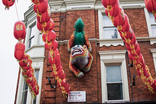 On Wardour Street in the city's Chinatown, view of a Chinese lion climbing among lanterns in one of the buildings. Photograph taken in London, England, United Kingdom