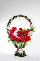 Basket with artificial flowers on a gray background