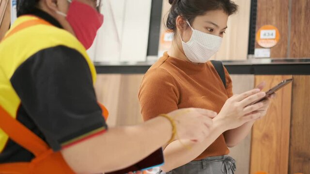 asian female customer with face mask protection discuss and suggest by sale assitant at home appliances section in department store both wear protection mask from covid-19 new normal lifestyle