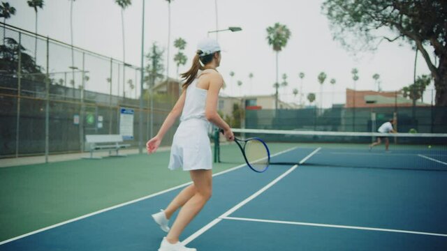 Female tennis player swinging a ball while match, playing professional tennis, strained game